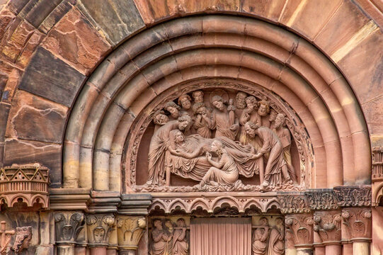 Gothic stone relief depicting the Dormition of the Virgin surrounded by the Apostles on the south transept portal of Strasbourg Cathedral in France.