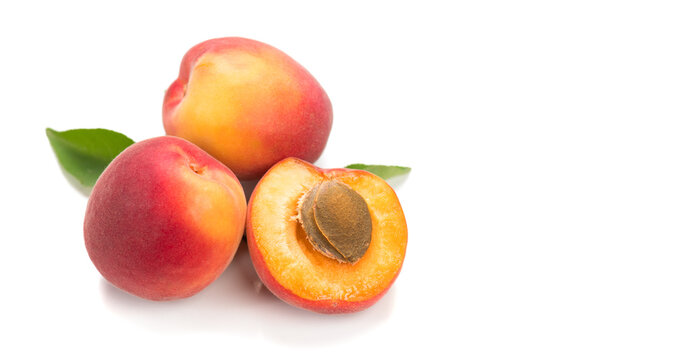Apricots fruit. Close-up of fresh organic apricot sweet fruits isolated on white background. Fresh bio apricot with leaves, top view, border design 