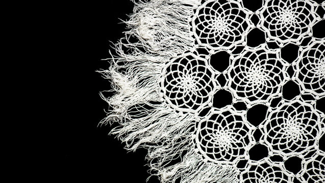 Crochet lace patterns border, crocheted Grandma's Doily, detail of hand-crocheted embroidery, tablecloth, napkin isolated on black background border art design. Craft, vintage linen. Hobby concept