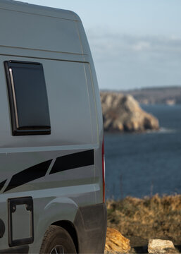 View of a camper van parked near the rugged cliffs of Pen Hir with the Atlantic Ocean in the background, Camaret-sur-Mer, Bretagne, France.