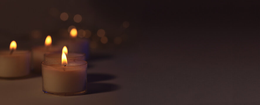 Soft focus. blur Burning candles in dark. Evening, night Light and shadow brown background. Minimalist still life.