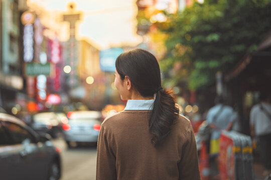 Woman walking through Yaowarat Road in Bangkok Chinatown, exploring famous urban travel destination in Thailand