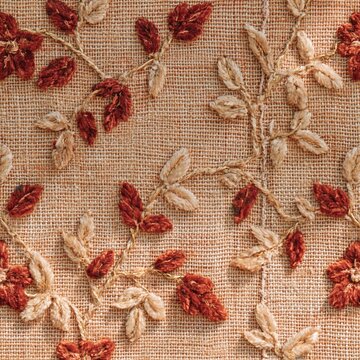 Red embroidered velvet fabric with a repeating vine pattern, featuring a tactile raised relief and a mended seam for a Jewish holiday mockup