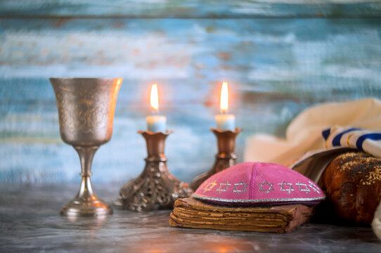 Jewish religious Shabbat ceremony are arranged on table with candles lit
