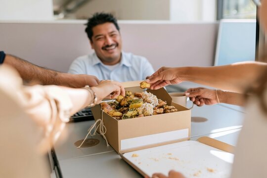 Assorted mithai sweets in a kraft box on an office desk, shared by colleagues in a natural moment for workplace diversity and team bonding, with copy space