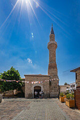 Fototapeta premium Historic mosque and stone minaret above an entrance courtyard in old town Antalya, Turkey.