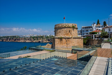 Fototapeta premium Wide coastal scene with Hidirlik Tower, sea, and park terrace in Antalya, Turkey.