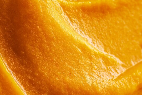 Close up of orange food paste spread on a surface showing texture and color