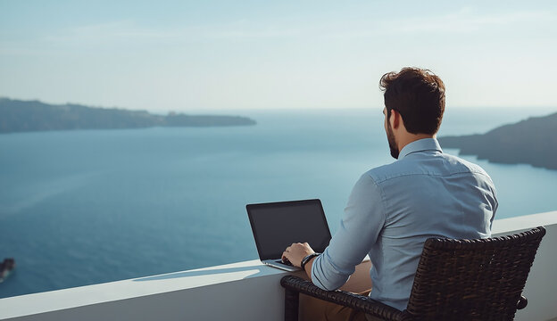A man in casual attire sitting on a chair, using a laptop for work or leisure.
