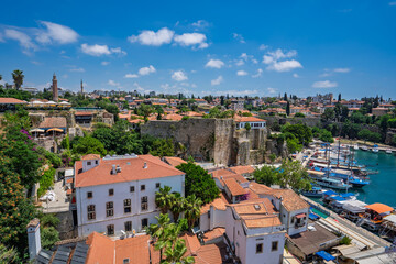 Fototapeta premium Historic Kaleici rooftops and marina beneath summer clouds in Antalya, Turkey.