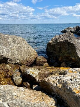 Large Coastal Rocks Against Deep Blue Sea and Cloudy Sky