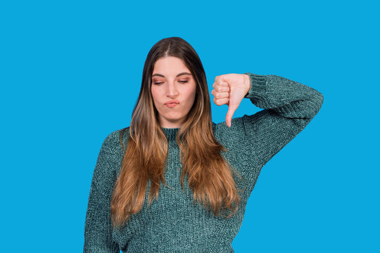 Woman expressing dislike showing thumbs down gesture