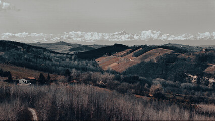Wide rural landscape with rolling hills, winter fields, distant mountains, cloudy sky, soft daylight, and layered horizon creating calm natural scenery for travel and outdoor themes © Ivan