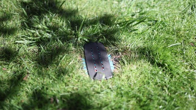 Automatic lawn irrigation sprinkler sits hidden in green grass providing efficient garden watering for a healthy lawn landscaping maintenance and convenient home care