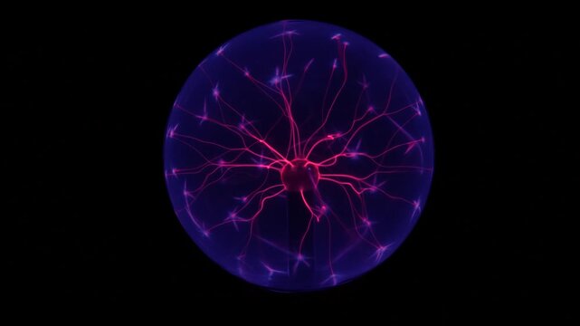 Boule plasma en verre illumin&eacute;e dans l&rsquo;obscurit&eacute;, parcourue de nombreux &eacute;clairs lumineux color&eacute;s qui convergent vers son centre. 