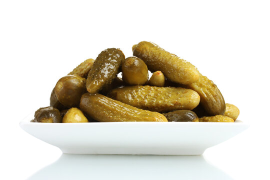 Delicious pickled cucumbers gherkins stacked on a white plate isolated background with cucumber