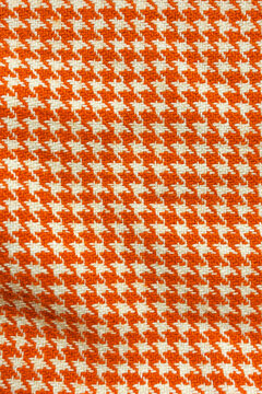 Macro texture of orange and cream houndstooth knitted textile for autumn fashion