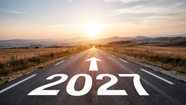 A long asphalt road with a white arrow and the number 2027 painted on it, stretching into the distance towards a bright sunset over green fields and mountains symbolizing future direction.