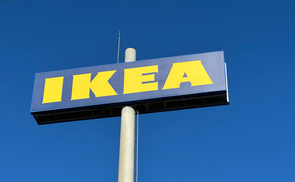 Clear low-angle outdoor shot of a large prominent IKEA store sign with bright yellow letters on a blue 