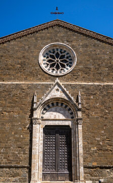 die Kirche Oro di Montalciono Complesso di Santi mit dem Turm des Palazzo dei Priori im Bildhintergrund, Montalcino, Toskana, Italien