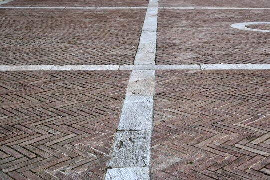 Top view of herringbone brick pavement with white marble lines Piazza Pio II Pienza Tuscany Italy for architecture background