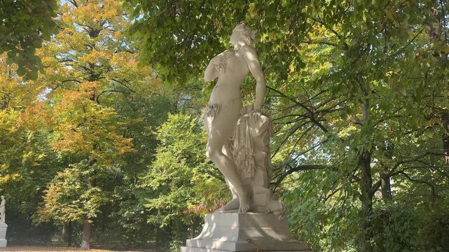 Italy, August 17, 2025.
Classical Female Statue with Falling Autumn Leaves in a Garden.
Author: Djundiet A.