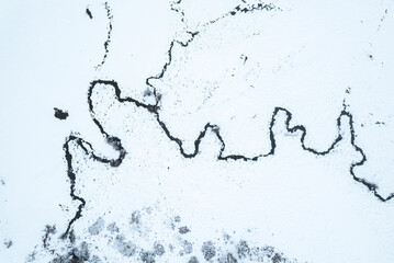 Obraz premium Aerial top down view of river in snowy landscape The Concept of solitude