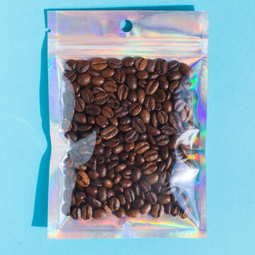 Blank craft plastic pouch mock up with coffee beans inside, transparent pack on studio background with shadow, mylar bag isolated for coffee product