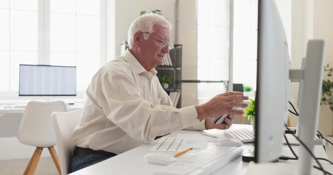 Senior man accountant working with tablet computer. Side view in office reviewing spreadsheet and finance figures, validating budgets and reports. Concept of reliable financial expertise.