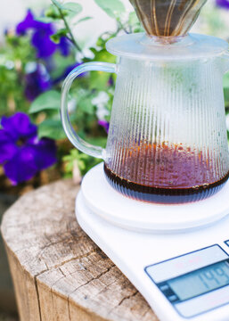 Pour over filter with ground coffee in the funnel in focus. Drip filter coffee brewing. Pour over alternative method of pouring water over roasted and ground coffee beans contained in filter