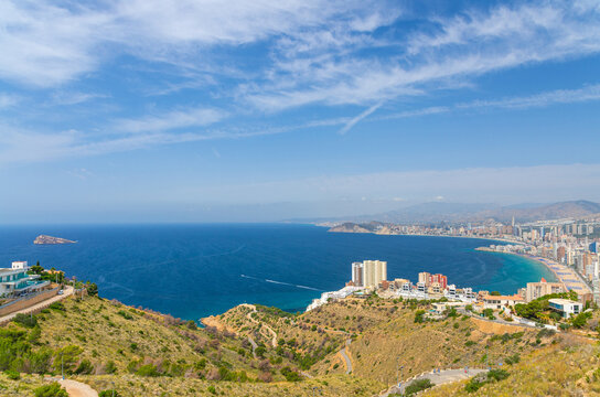 Aerial panoramic view of Benidorm bay Mediterranean Sea with Isla de Benidorm island, Costa Blanca coastline Benidorm city coast, skyscrapers, hotel buildings, beach, Serra Gelada natural park, Spain