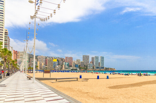 Levante sandy beach Playa Platja De Llevant embankment promenade in Benidorm city centre with hotel buildings on Costa Blanca coast Mediterranean Sea in summer day, Valencian Community, Spain