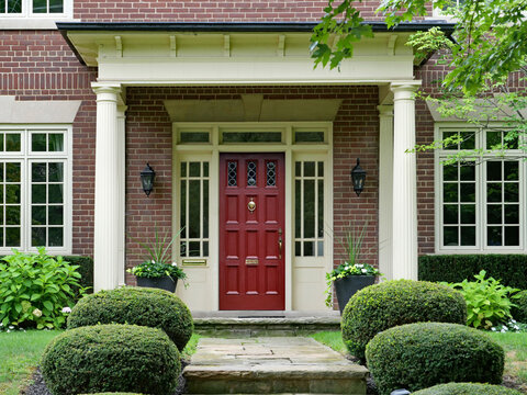 Front door of two story brick house with portico entrance