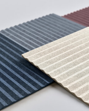 Stacked corrugated panels in blue, beige, and maroon colors with parallel ridged textures