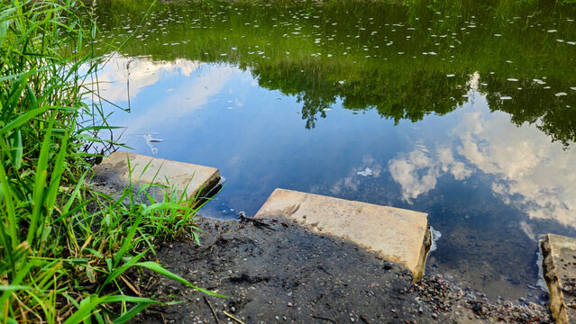 Concrete blocks positioned to act as a subbase foundation for a riverbank staircase, exposed during a period of low rainfall. watershed area and environment concepts 