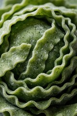 Obraz premium Close up of fresh green pasta made with spinach herbs. Homemade durum wheat dough shows rough texture, organic quality. Raw italian noodles nest in swirl shape for healthy culinary cooking. Artisan