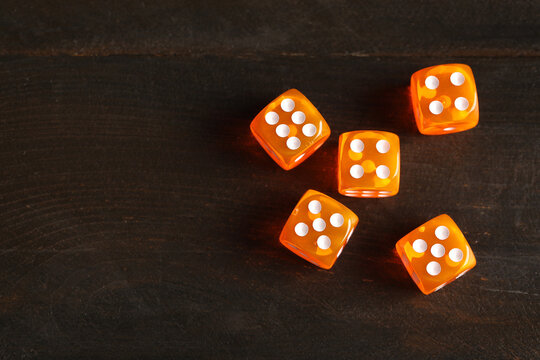 Orange game dices on wooden background