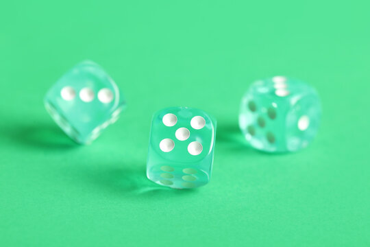 Turquoise game dices on green background