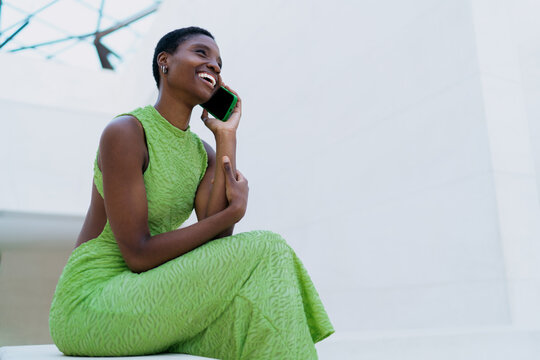 Dark skinned model phone call talking smile. Cheerful African American woman on smartphone conversation operator connection, sharing vacation holidays trip details near copy space.