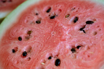 macro close-up of a pink watermelon with seeds. black diamond background © mailcaroline