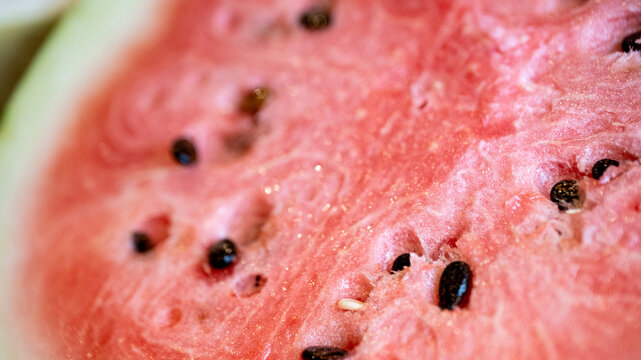 macro close-up of ripe, cut watermelon with pink gradient and seeds. fruit banner with copy space