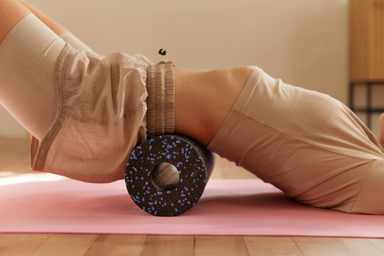 Woman Doing Back Self Massage With Foam Roller On Mat