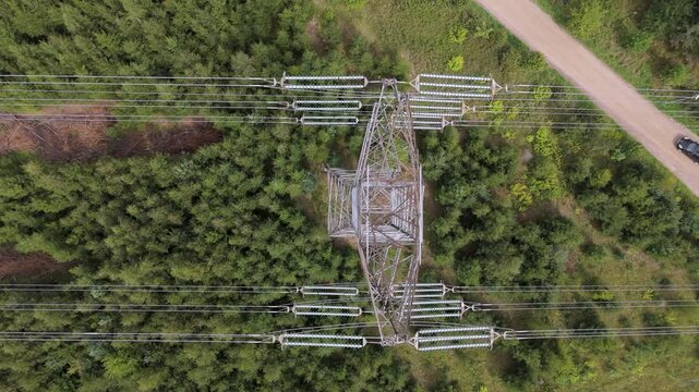 Aerial View: High-Voltage Power Transmission Pylon Insulators in Forest Landscape