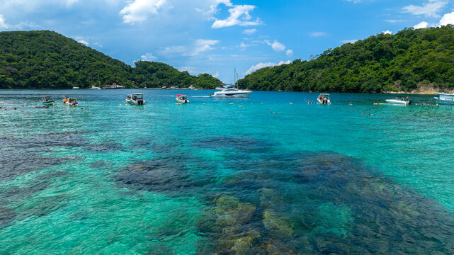 Aerial view of Lagoa Azul with turquoise waters, boats, and lush green hills in Angra dos Reis, Rio de Janeiro, Brazil.