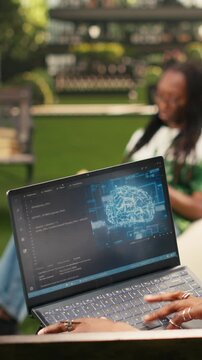 Vertical frame: The IT engineering student uses AI and binary code on a laptop screen, with programming, deep learning and neural networks visible during coding practice on a modern campus bench.