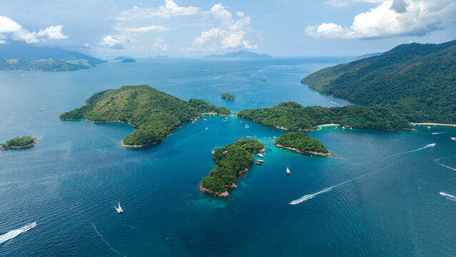 Aerial view of Lagoa Azul with turquoise waters, lush green islands, and boats navigating the bay in Angra dos Reis, Rio de Janeiro, Brazil.