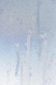 Gros plan sur des gouttes d'eau de condensation. Le format est vertical.