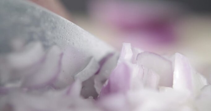 Tabletop Macro Close up of kitchen knife chopping onions in slow motion
