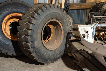 Fototapeta premium Close up of large heavy equipment tires and rims stored inside a municipal maintenance garage