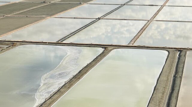 Aerial view of salt pans in Narta Lagoon with reflective water surfaces and earthen dikes Vlore, Vlore County, Albania.